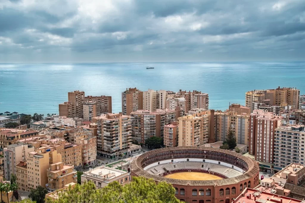 Aerial view of Málaga, Spain, showcasing the historic La Malagueta bullring prominently in the foreground.