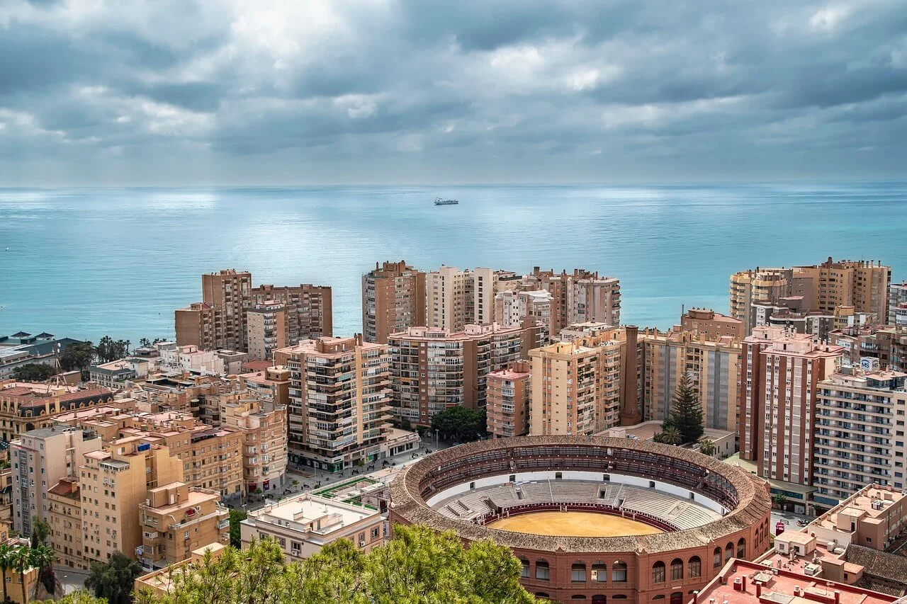 Aerial view of Málaga, Spain, showcasing the historic La Malagueta bullring prominently in the foreground.