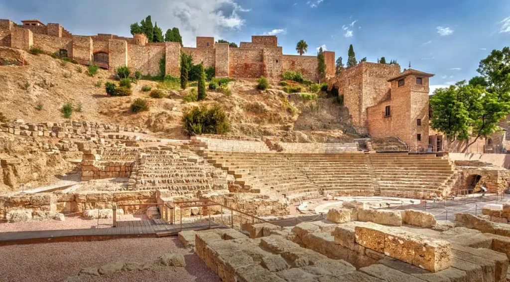 Alcazaba fortress, with its extensive walls and towers, situated on the hill directly behind and above the theatre.